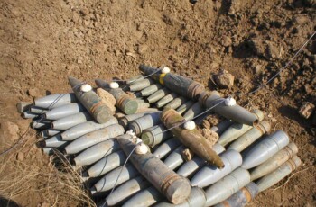 Pile of unexploded bombs in a crater waiting to be disposed of overseas