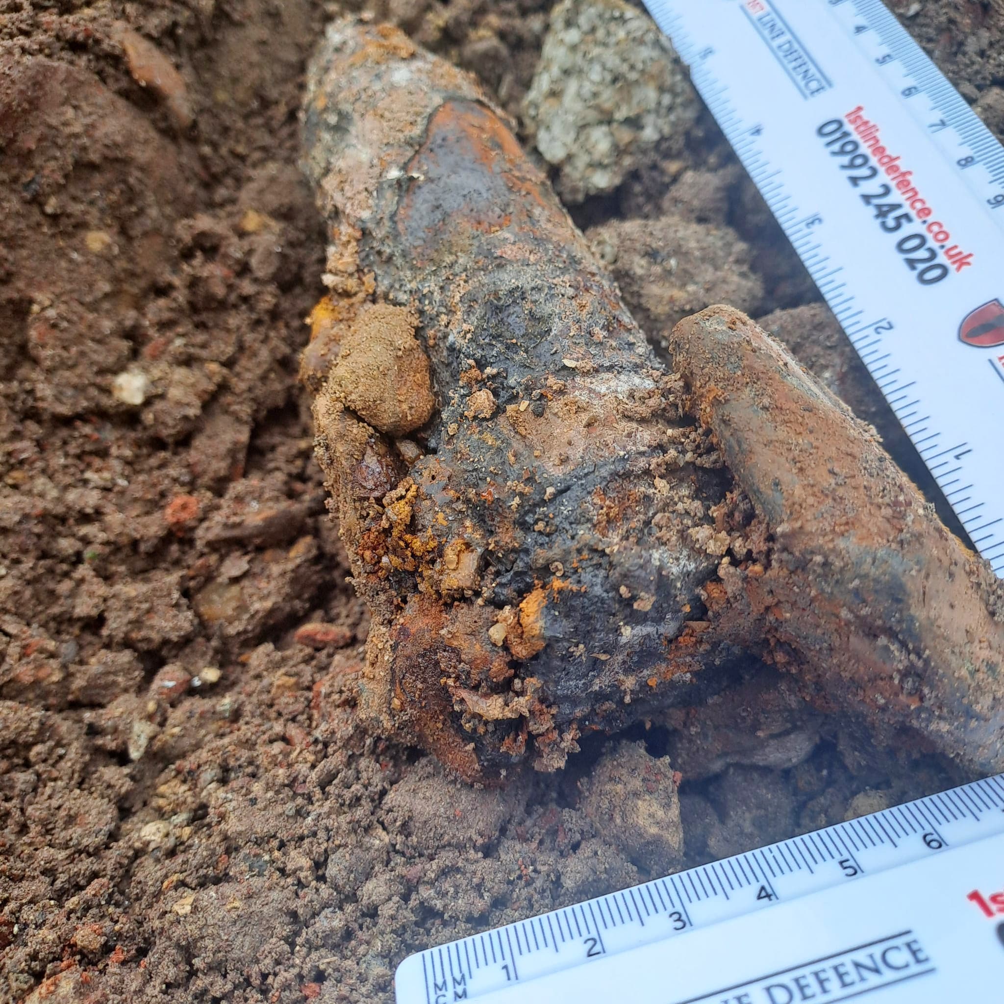 Close-up of a 40mm Bofors round (with rulers for scale) which was discovered on a development site in Portsmouth by 1st Line Defence.